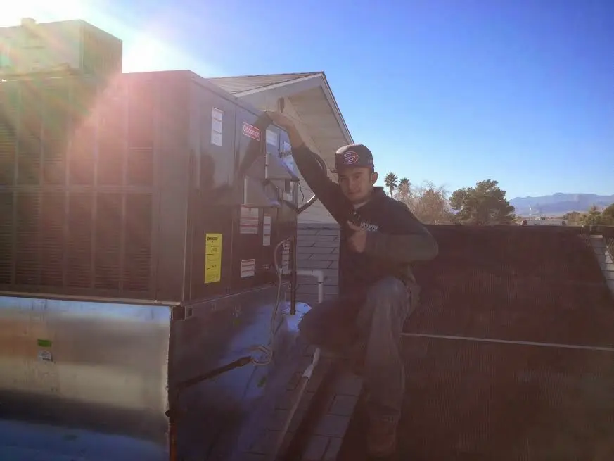 HVAC technician performing AC Tune-Up on a rooftop unit in Scarborough